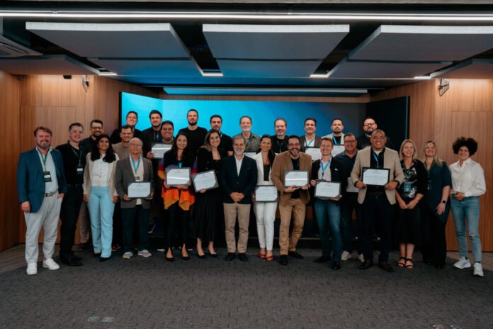 Formandos do programa Sala do Conselho posam juntos segurando seus certificados, simbolizando o avanço da governança corporativa e a formação de novos conselheiros consultivos no Brasil, sob coordenação de Márcio Giacobelli e o Advisory Board Institute.