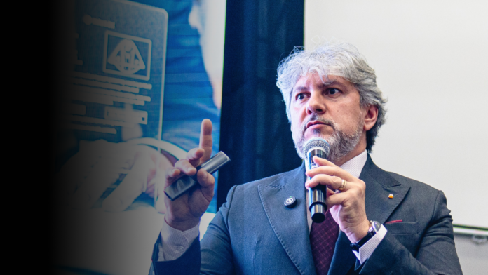 MEnezes (1) Luciano Menezes durante palestra, segurando microfone e fazendo gesto técnico, em ambiente corporativo, abordando estratégia fiscal e gestão empresarial.